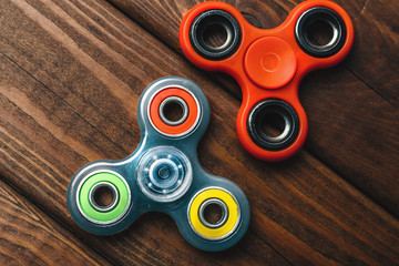 Two Fidget Spinners popular trend stress relieving toy on wood