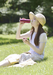 水筒の水を飲む女性