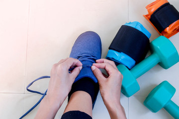 Young woman tying shoelaces in fitness