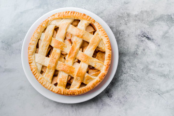 Popular American apple pie on gray table. Homemade classical friut tart. Copy space