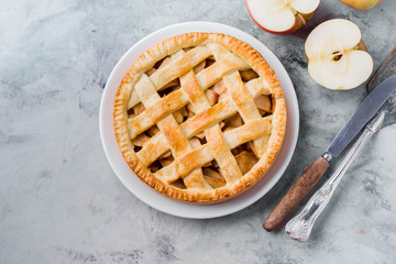 Popular American apple pie on gray table. Homemade classical friut tart. Copy space