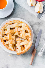 Popular American apple pie and cup of tea on gray table. Homemade classical friut tart. Copy space