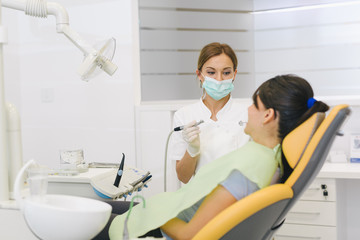 Fototapeta na wymiar Woman repairing teeth at the dentist office