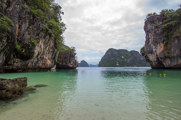 Naklejka premium Small bay surrounded by intricate limestone,soft white sand beach and emerald color sea at Lading island(Paradise island) in Krabi province,Southern Thailand.