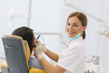 Work is a pleasure for her. Woman dentis at her office