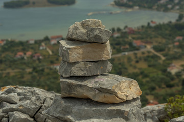 zen stones at the top of the hill with city Mrljane and sea in background