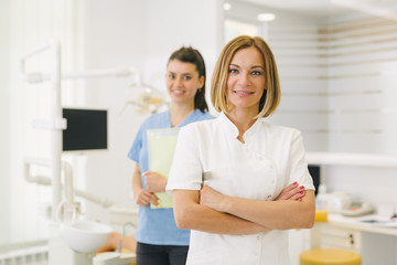 Work is a pleasure for them. woman dentist and her assistant at the dentist office