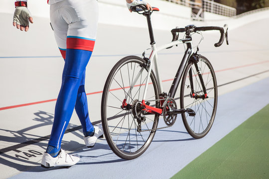 Racing cyclist on velodrome outdoor.