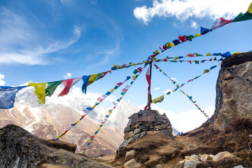 Swinging prayer flags over stone stupa on Everest Base Camp Trek, Gokyo valley, Sagarmatha National Park, Nepal. 