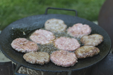 Grilling beefburgers on hot oil