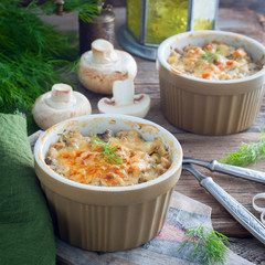 Two bowls of hot Julienne with mushrooms, cream sauce and cheese on cutting board on wooden background,square