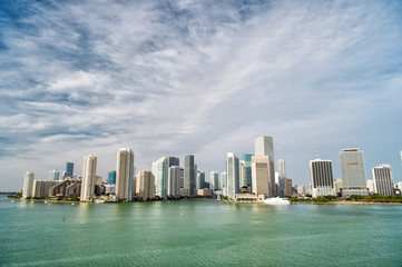 Fototapeta na wymiar Miami skyscrapers with blue cloudy sky, boat sail, Aerial view