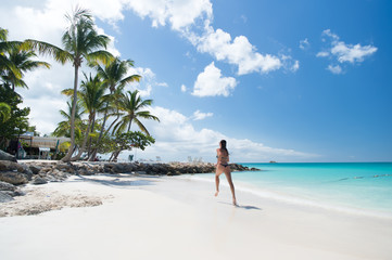 Young woman running at the tropical beach