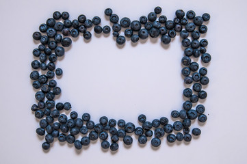 Blueberries isolated on white background. Blueberry border design. Ripe and juicy fresh picked bilberries close up. Copyspace. Top view or flat lay