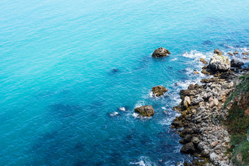 Fototapeta na wymiar Blue Vibrant Sea Water With Rocks