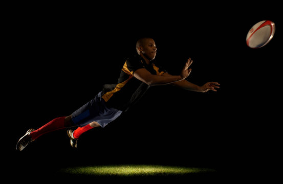 Rugby player diving whilst passing ball