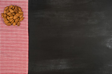 Almonds on a kitchen napkin and black chalkboard.