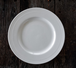 empty white plate on wooden