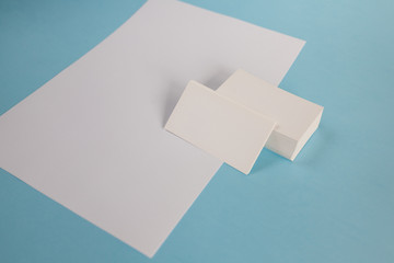 White paper A4 and a business card on a blue background. Brochure mockup