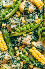 healthy diet. Casserole with potatoes, corn, green peas and spinach and parmesan cheese, basil. In white form for baking on a wooden table