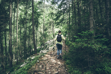 Young lady hiker with backpack walking in carpathian