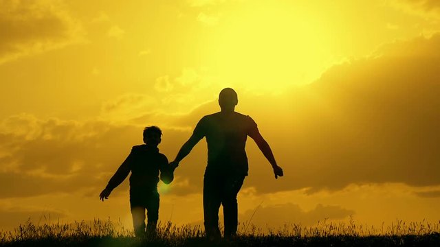 Father and son play in the park during sunset. The concept of a united family.