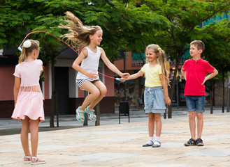 children with jumping rope at playground.