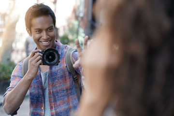 Young man taking picture of model in the street