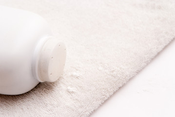 Fototapeta na wymiar talcum powder on a soft white towel background