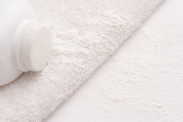 Fototapeta na wymiar talcum powder on a soft white towel background