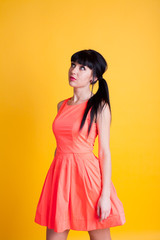 girl in orange dress on a yellow background