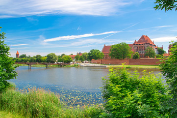 Obraz premium Malbork Castle and the river Nogat in Poland. Castle of the Teutonic Order in Malbork is the largest castle in the world measured by land area.