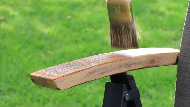painting wooden garden chair with brush
