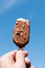 Biten ice cream against blue sky.