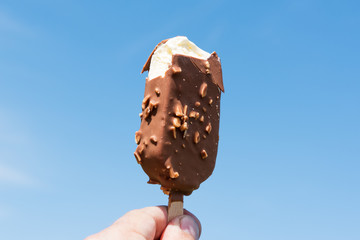 Biten ice cream against blue sky.