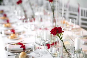 Formal dinner table setting with red roses