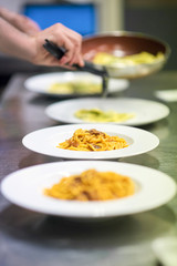 Chef serving or plating up pasta in a restaurant