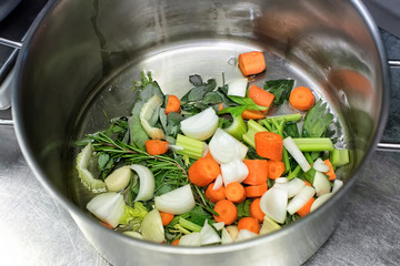 Diced fresh vegetables and herbs in a saucepan