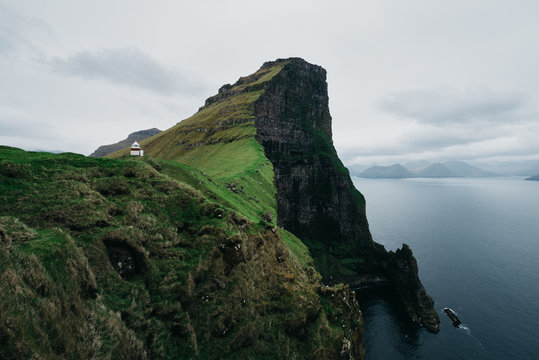 Lighthouse standing above jagged cliffs