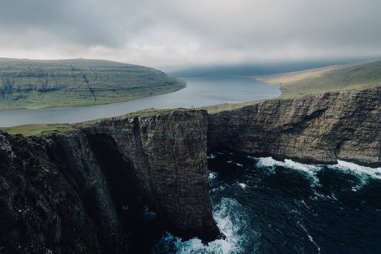 Tiny person giving sense of scale at cliff landscape