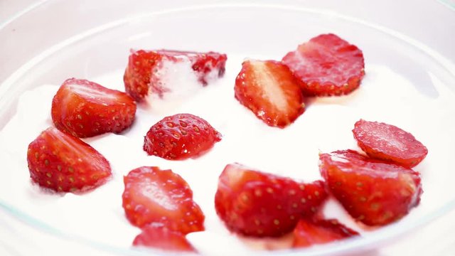 Pieces of strawberry is taken from cream by spoon. Macro shot. time lapse.