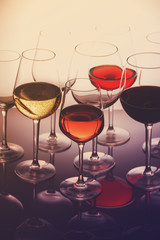 Set of glasses with red, white and rose wine close up, retro toned