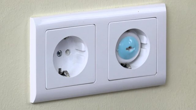 Hands install safety plugs in electricity outlet on wall