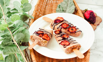 Homemade strawberry yogurt ice cream popsicles ,Summer dessert with chocolate.