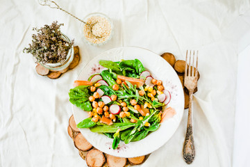 Green salad with arugula, corn, carrots and baked chickpeas.Healthy vegetarian meal concept.