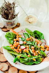 Green salad with arugula, corn, carrots and baked chickpeas.Healthy vegetarian meal concept.