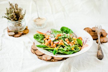 Green salad with arugula, corn, carrots and baked chickpeas.Healthy vegetarian meal concept.