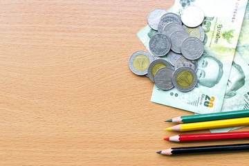 Pencil and money on a wooden  using wallpaper or background for  business work.