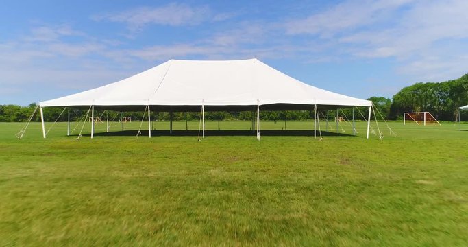 Precision fast drone flying through, under pavilion tent. 
