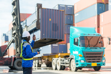 Naklejka premium Foreman control loading Containers box from Cargo freight ship for logistics import export background.